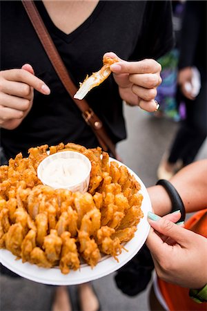 Hands holding plate of blooming onion with dip Stock Photo - Premium Royalty-Free, Code: 649-08565454