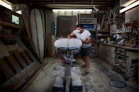 surf sport - Mature man sanding a surfboard in his workshop Stock Photo - Premium Royalty-Free, Code: 649-08565634