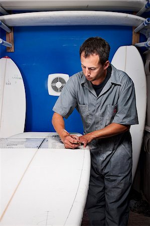 regla (para medir) - Mid adult man measuring surfboard in his workshop Foto de stock - Sin royalties Premium, Código: 649-08565639