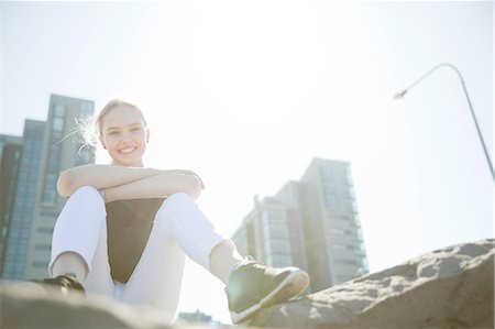 simsearch:649-08560718,k - Low angle view of high rise buildings and teenage girl sitting on rocks looking at camera smiling, Reykjavik, Iceland Photographie de stock - Premium Libres de Droits, Code: 649-08565906