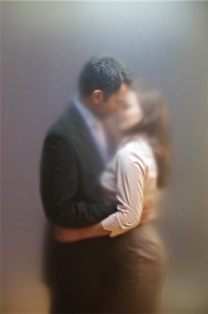 Co-workers kissing behind frosted screen Stock Photo - Premium Royalty-Free, Code: 649-08560069