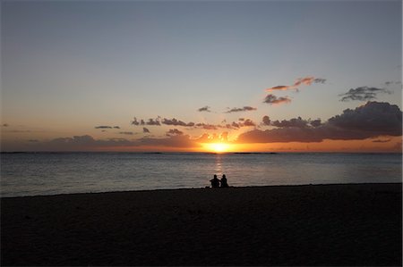 Couple sitting on beach at sunset Foto de stock - Sin royalties Premium, Código: 649-08560747