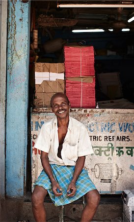 portrait mature indian not summer not children - Smiling man sitting in front of shop Stock Photo - Premium Royalty-Free, Code: 649-08560995