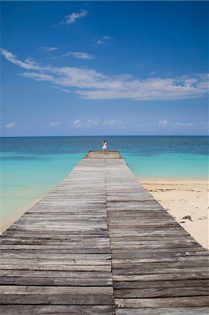 simsearch:6113-07160388,k - Woman on wooden pier on tropical beach Photographie de stock - Premium Libres de Droits, Code: 649-08561191