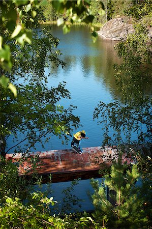 simsearch:695-05763508,k - Boy standing on dock in lake Photographie de stock - Premium Libres de Droits, Code: 649-08561346