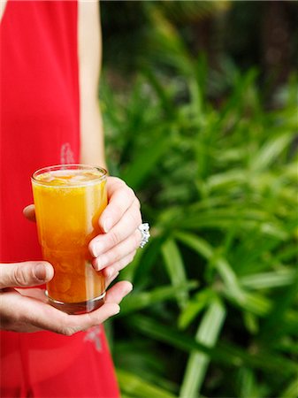 ponche de frutas - Woman holding glass of juice Foto de stock - Royalty Free Premium, Número: 649-08561605