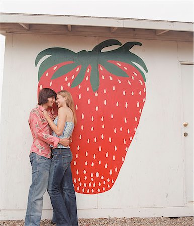simsearch:614-06623937,k - Couple hugging by fruit mural Stock Photo - Premium Royalty-Free, Code: 649-08561817