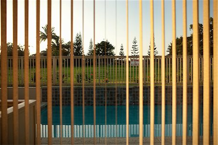 simsearch:649-08562431,k - View of swimming pool through window blinds Stock Photo - Premium Royalty-Free, Code: 649-08562431