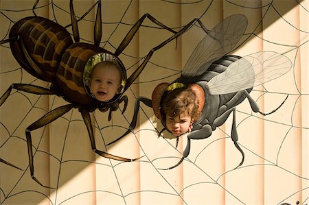 Toddler boy and young girl with heads through holes painted like insects Stock Photo - Premium Royalty-Free, Code: 649-08562622