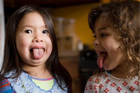 Two young girls sticking out their tongues Photographie de stock - Premium Libres de Droits, Code: 649-08562884
