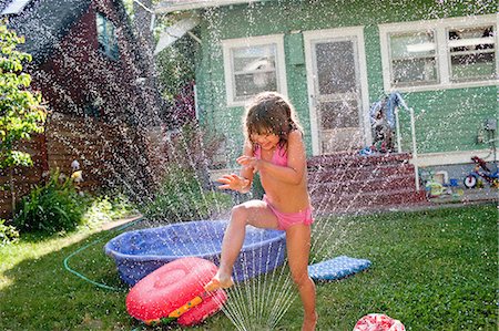 Young girl playing in garden sprinkler Photographie de stock - Premium Libres de Droits, Code: 649-08563035