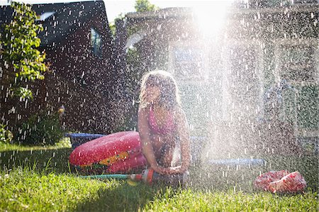 Young girl playing in garden sprinkler Stock Photo - Premium Royalty-Free, Code: 649-08563036