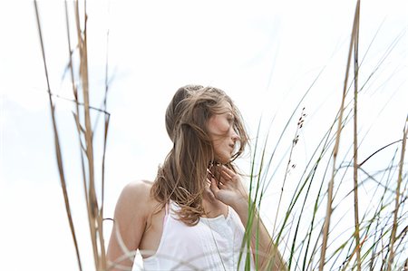 simsearch:6113-07808423,k - Young woman in grass, looking away Stock Photo - Premium Royalty-Free, Code: 649-08563126