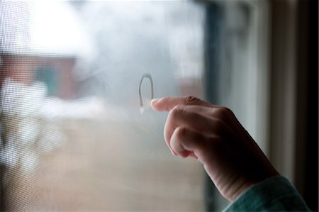 Girl drawing in condensation on window Stock Photo - Premium Royalty-Free, Code: 649-08563308