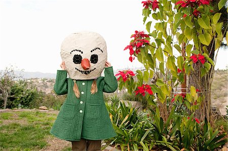 Girl wearing snowman head in backyard Foto de stock - Sin royalties Premium, Código: 649-08563983