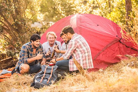 simsearch:649-08576582,k - Men drinking beer whilst  preparing food on camping stove in forest, Deer Park, Cape Town, South Africa Stock Photo - Premium Royalty-Free, Code: 649-08576294