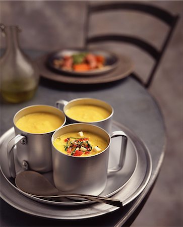 simsearch:649-08479771,k - Yellow pepper soup with tomatoes, feta cheese and herb garnish, in metal cups Photographie de stock - Premium Libres de Droits, Code: 649-08576313