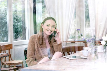 View through glass of woman sitting at table making telephone call smiling Foto de stock - Sin royalties Premium, Código: 649-08576324