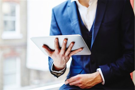 Cropped view of man wearing suit holding digital tablet Stock Photo - Premium Royalty-Free, Code: 649-08576339