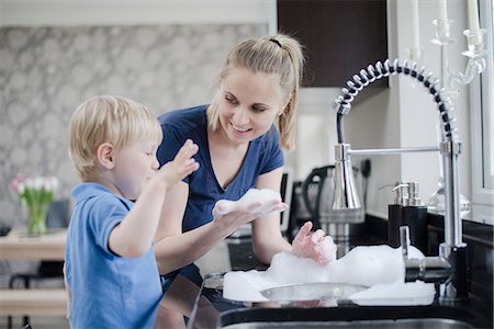 simsearch:649-08576682,k - Mother and son doing washing up together Fotografie stock - Premium Royalty-Free, Codice: 649-08576685