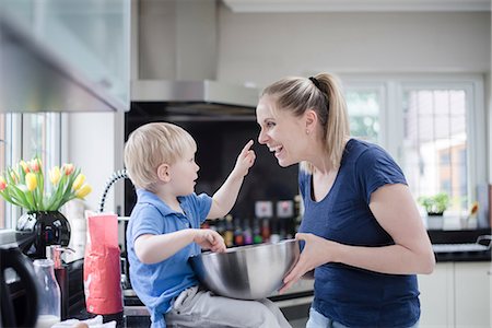 simsearch:649-08576682,k - Mother and son fooling around whilst baking, son putting mixture on mother's nose Fotografie stock - Premium Royalty-Free, Codice: 649-08576683