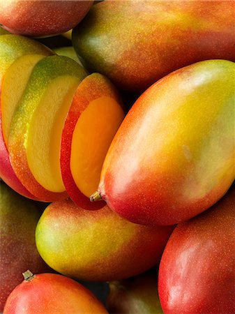 Mangoes, whole and sliced, close-up Photographie de stock - Premium Libres de Droits, Code: 649-08576713