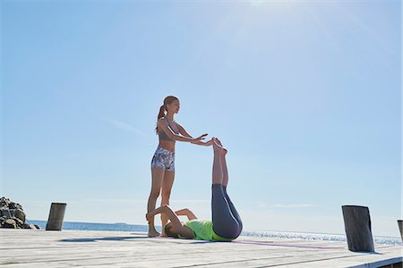 Women on pier holding each others ankles exercising Photographie de stock - Premium Libres de Droits, Code: 649-08576735