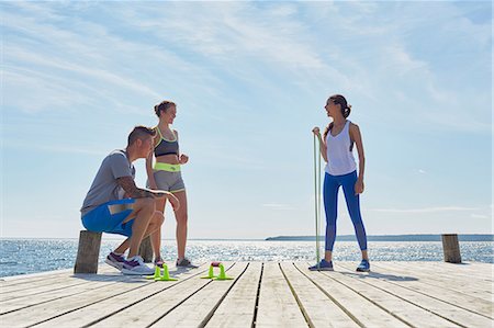 resistance band and men - Friends wearing sports clothes on pier with exercise equipment Stock Photo - Premium Royalty-Free, Code: 649-08576745