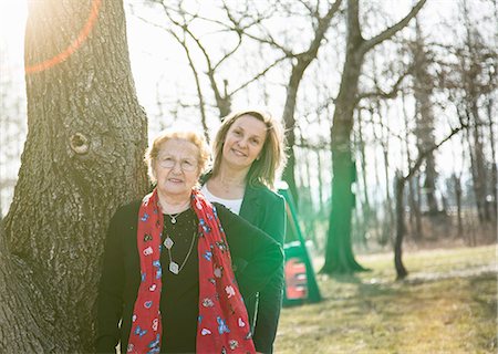 Adult daughter standing behind mother by tree looking at camera smiling Photographie de stock - Premium Libres de Droits, Code: 649-08576775