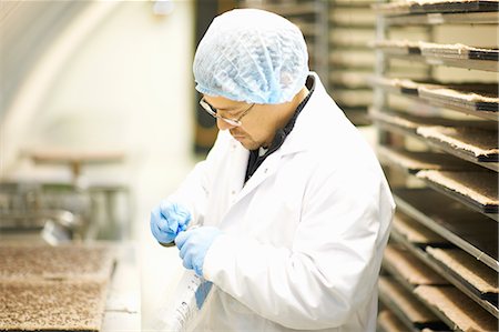factory workers hairnet - Side view of worker wearing hairnet and latex gloves collecting samples in plastic bag Stock Photo - Premium Royalty-Free, Code: 649-08576791