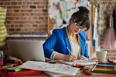 sketching a jacket - Woman in design studio sitting at desk sketching fashion design Stock Photo - Premium Royalty-Free, Code: 649-08576827