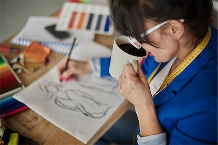 sketching a jacket - Over shoulder view of woman in design studio drinking coffee, sketching fashion design Stock Photo - Premium Royalty-Free, Code: 649-08576838