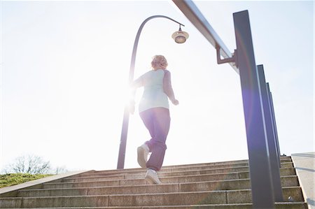 simsearch:649-08306424,k - Low angle rear view of woman running up steps Photographie de stock - Premium Libres de Droits, Code: 649-08576846