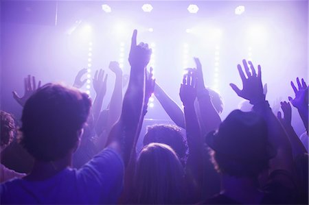 Rear view of group in club arms raised watching concert Foto de stock - Sin royalties Premium, Código: 649-08576877