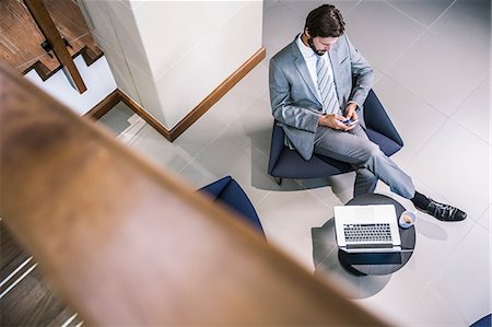 simsearch:649-09035452,k - High angle view of businessman in lobby looking down at smartphone Stockbilder - Premium RF Lizenzfrei, Bildnummer: 649-08576936