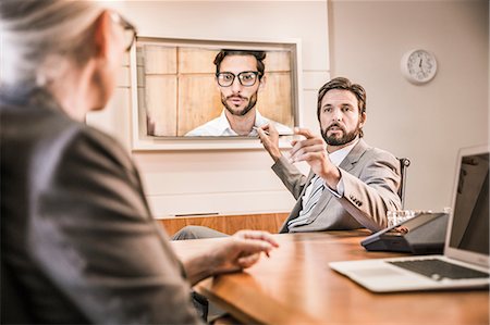 skype - Over the shoulder view of business people in boardroom having video call meeting Foto de stock - Sin royalties Premium, Código: 649-08576953