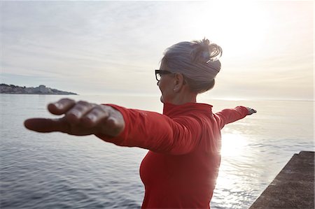 simsearch:649-08381569,k - Mature woman standing beside water, in yoga position, rear view Stock Photo - Premium Royalty-Free, Code: 649-08577005