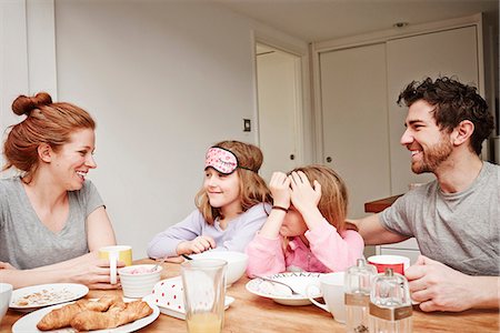 Mid adult parents at breakfast table with two daughters Stock Photo - Premium Royalty-Free, Code: 649-08577228