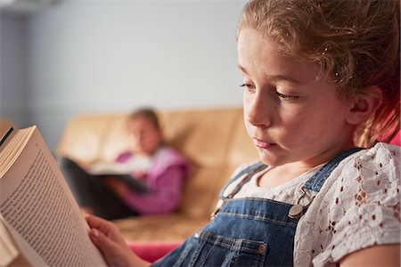 simsearch:632-05760667,k - Close up of girl and her sister reading books in living room Foto de stock - Royalty Free Premium, Número: 649-08577240