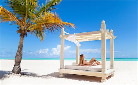 Young woman wearing bikini sunbathing on beach daybed, Dominican Republic, The Caribbean Stock Photo - Premium Royalty-Free, Code: 649-08577339