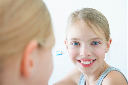 Bathroom mirror portrait of girl holding toothbrush Stock Photo - Premium Royalty-Free, Code: 649-08577448