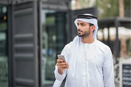 dishdasha - Man wearing traditional middle eastern clothing using smartphone, Dubai, United Arab Emirates Stock Photo - Premium Royalty-Free, Code: 649-08577552