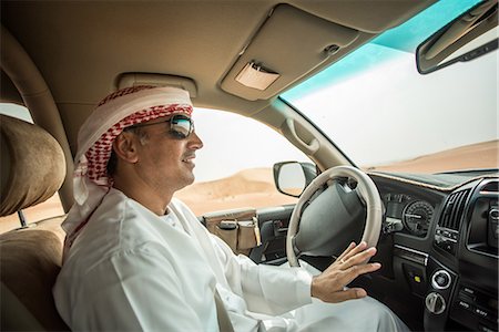 simsearch:649-08577597,k - Middle eastern man wearing traditional clothes driving off road vehicle in desert, Dubai, United Arab Emirates Photographie de stock - Premium Libres de Droits, Code: 649-08577568