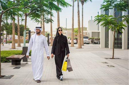 Middle eastern shopping couple  wearing traditional clothing walking along street, Dubai, United Arab Emirates Photographie de stock - Premium Libres de Droits, Code: 649-08577561
