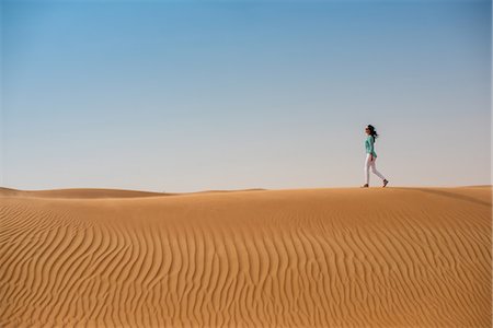 simsearch:6102-08566362,k - Woman tourist walking on desert dune, Dubai, United Arab Emirates Stock Photo - Premium Royalty-Free, Code: 649-08577584