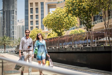 rich people outdoor - Couple strolling on walkway carrying shopping bags, Dubai, United Arab Emirates Stock Photo - Premium Royalty-Free, Code: 649-08577615