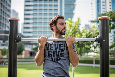 simsearch:649-08577624,k - Young man doing pull ups on park exercise equipment, Dubai, United Arab Emirates Foto de stock - Sin royalties Premium, Código: 649-08577629