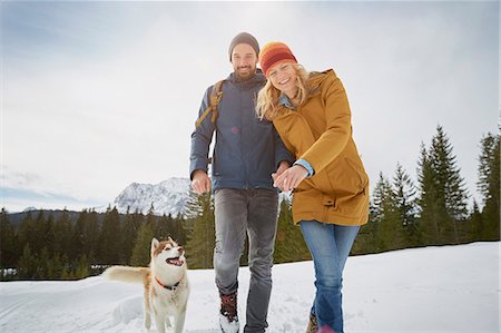 deutschland winter - Portrait of couple walking husky in snow covered landscape, Elmau, Bavaria, Germany Stock Photo - Premium Royalty-Free, Code: 649-08577738