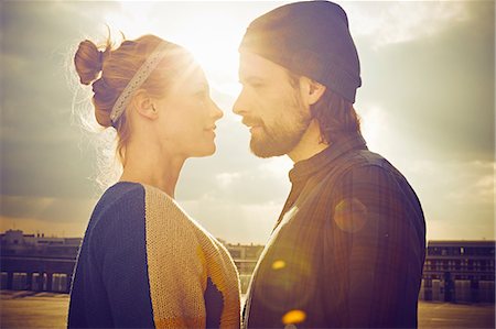 Sunlit portrait of mid adult couple face to face on rooftop parking lot Stock Photo - Premium Royalty-Free, Code: 649-08577764
