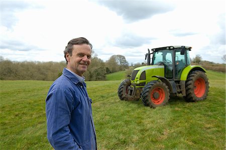 Portrait of farmer in field in front of tractor Stock Photo - Premium Royalty-Free, Code: 649-08577793